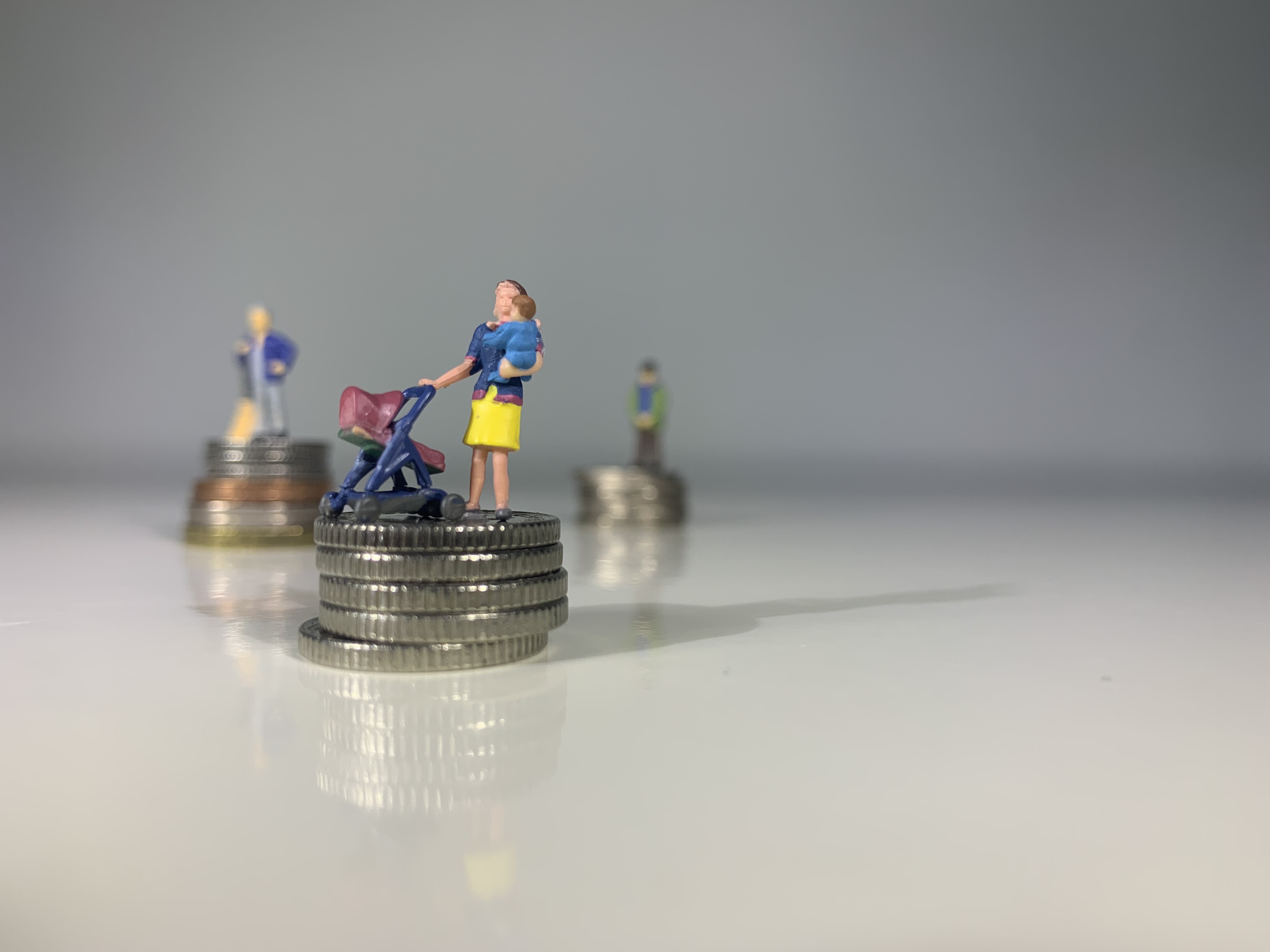 little people standing on stacks of coins
