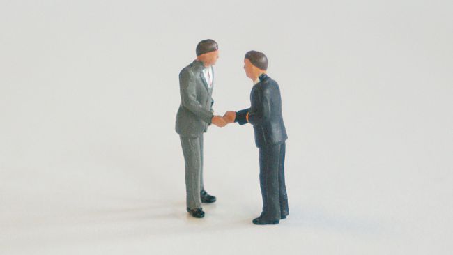 Small model figures shaking hands