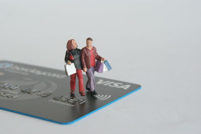 small model figures walking across a bank card